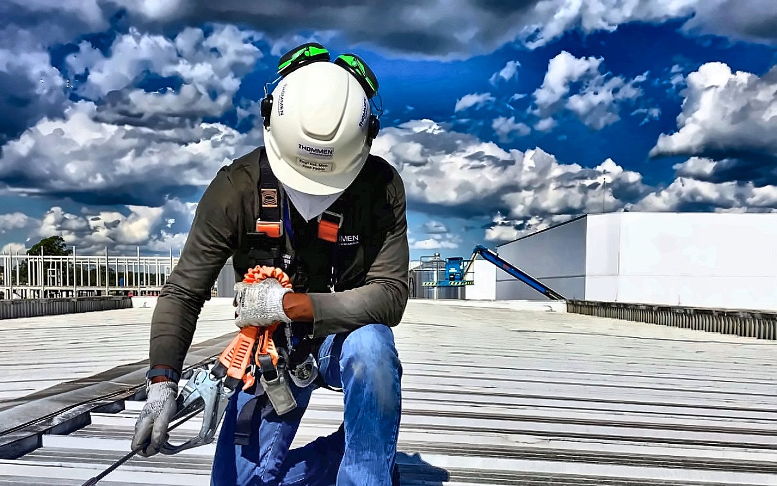 Trabalhador ancorado à linha de vida em cobertura industrial